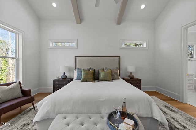 bedroom featuring multiple windows, wood finished floors, and beamed ceiling