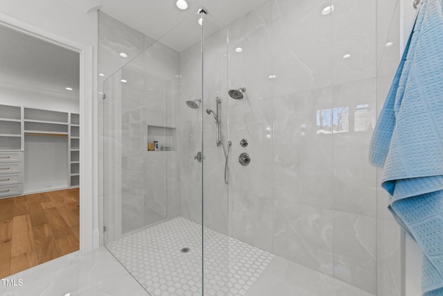 full bath featuring tiled shower and wood finished floors