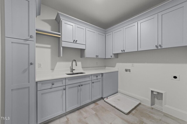 laundry area featuring cabinet space, baseboards, hookup for a washing machine, hookup for an electric dryer, and a sink