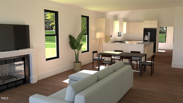 living area with a healthy amount of sunlight, dark wood-style floors, a fireplace, and baseboards