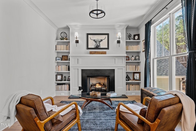 112 Rawhide Dr, Louisburg, NC 27549 - living area with a warm lit fireplace, crown molding, wood finished floors, and built in shelves