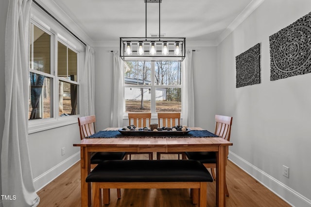 112 Rawhide Dr, Louisburg, NC 27549 - dining area featuring baseboards, light wood-type flooring, an inviting chandelier, and crown molding