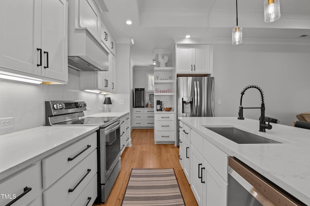 112 Rawhide Dr, Louisburg, NC 27549 - kitchen with white cabinetry, decorative light fixtures, stainless steel appliances, a sink, and light wood-style flooring