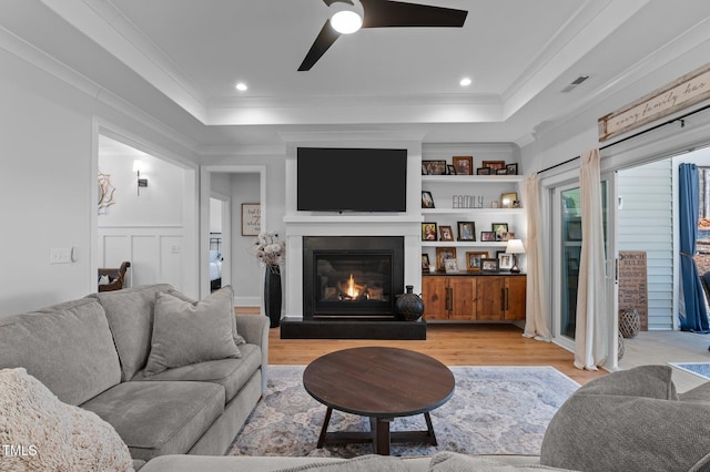 112 Rawhide Dr, Louisburg, NC 27549 - living room featuring a tray ceiling, light wood-style floors, ceiling fan, and ornamental molding