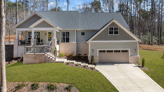 craftsman house featuring brick siding, a porch, concrete driveway, and a front yard