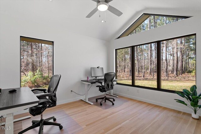 office space with high vaulted ceiling, wood finished floors, baseboards, and ceiling fan