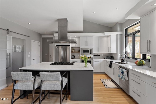 kitchen with a kitchen island, a sink, white cabinets, appliances with stainless steel finishes, and island range hood