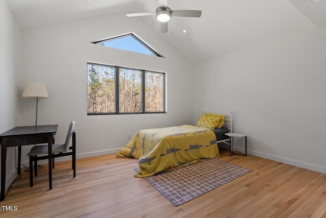 bedroom with ceiling fan, high vaulted ceiling, baseboards, and wood finished floors