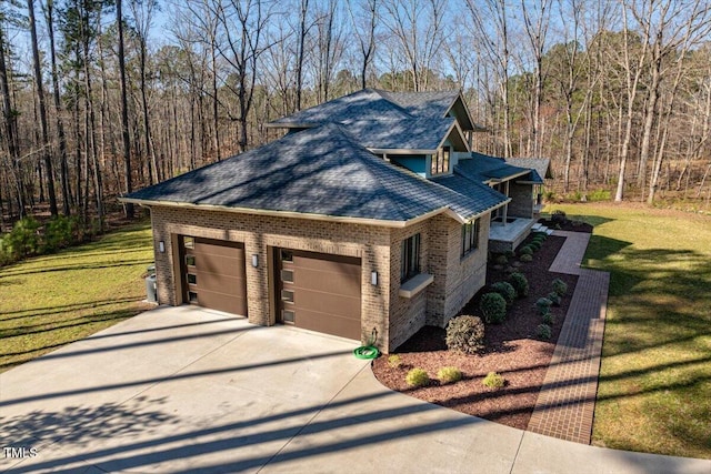 view of side of property with brick siding, a lawn, concrete driveway, and roof with shingles