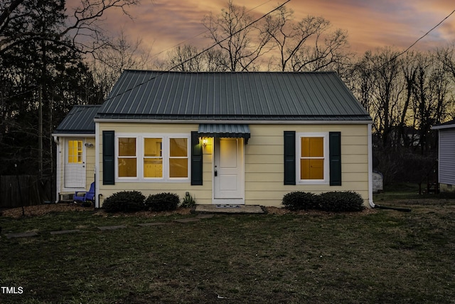 bungalow-style house featuring a front yard and metal roof