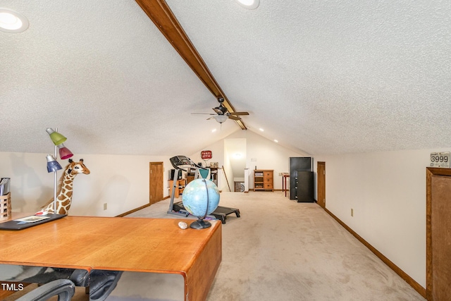 office space featuring baseboards, vaulted ceiling with beams, ceiling fan, a textured ceiling, and light colored carpet