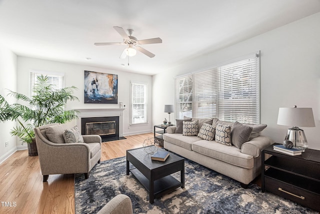 living room with a fireplace with flush hearth, a healthy amount of sunlight, and light wood finished floors