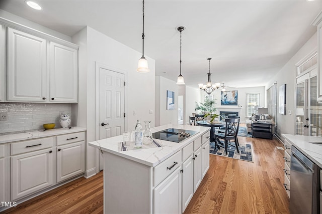 kitchen featuring stainless steel dishwasher, open floor plan, light wood finished floors, and a kitchen island