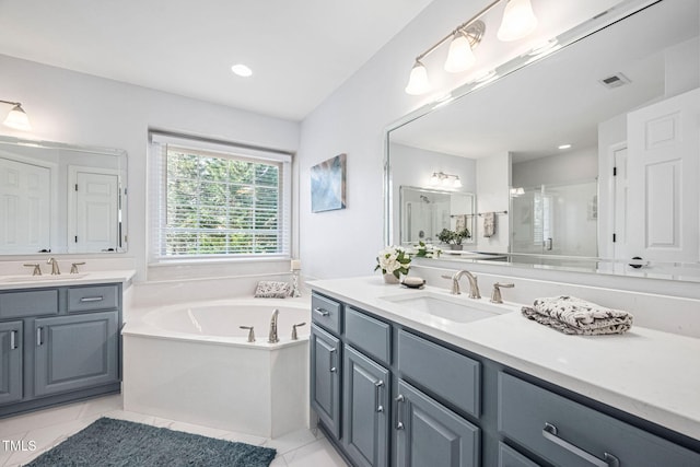 bathroom featuring visible vents, two vanities, a sink, a shower stall, and a bath