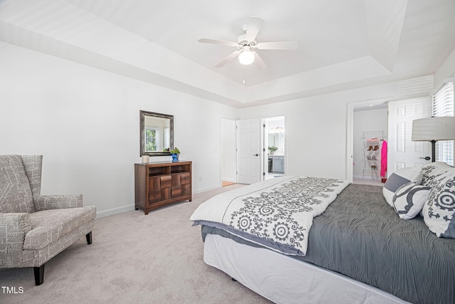 bedroom featuring light colored carpet, a ceiling fan, a raised ceiling, and baseboards