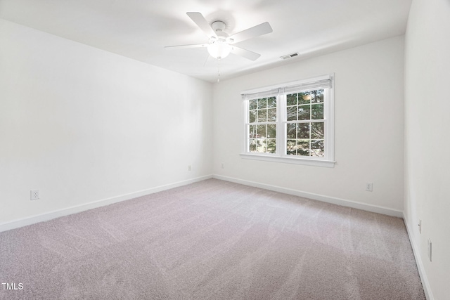 spare room featuring visible vents, light carpet, and baseboards