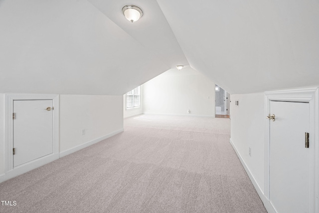 additional living space with carpet flooring, baseboards, and vaulted ceiling