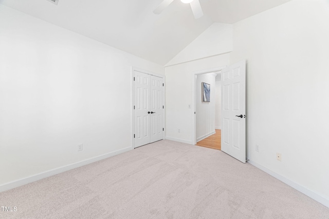 unfurnished bedroom with lofted ceiling, a ceiling fan, a closet, carpet, and baseboards