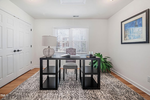 office featuring visible vents, baseboards, and wood finished floors