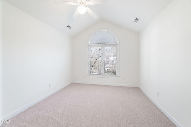 unfurnished room featuring vaulted ceiling, light colored carpet, visible vents, and baseboards