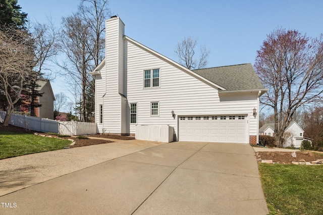 view of property exterior featuring roof with shingles, a chimney, driveway, and fence