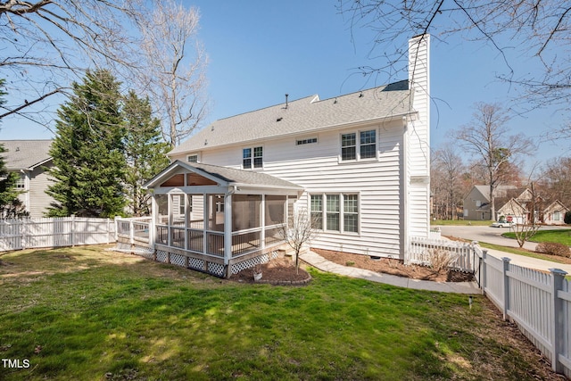 rear view of property with a fenced backyard, a lawn, a sunroom, and a chimney