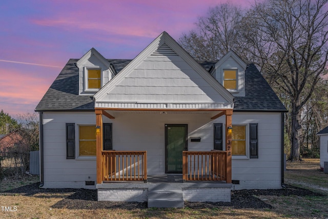 rear view of property with covered porch, roof with shingles, and crawl space