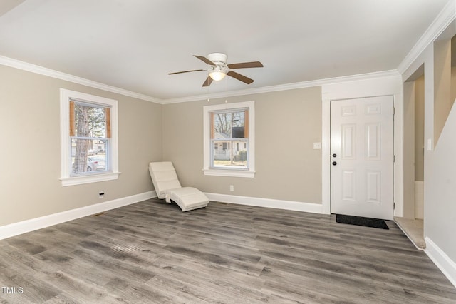 unfurnished room with baseboards, plenty of natural light, ornamental molding, and wood finished floors