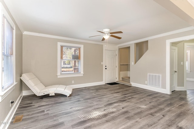 unfurnished room with baseboards, visible vents, stairway, ornamental molding, and wood finished floors