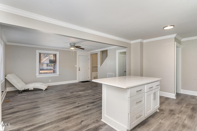 kitchen featuring a center island, white cabinets, baseboards, and wood finished floors