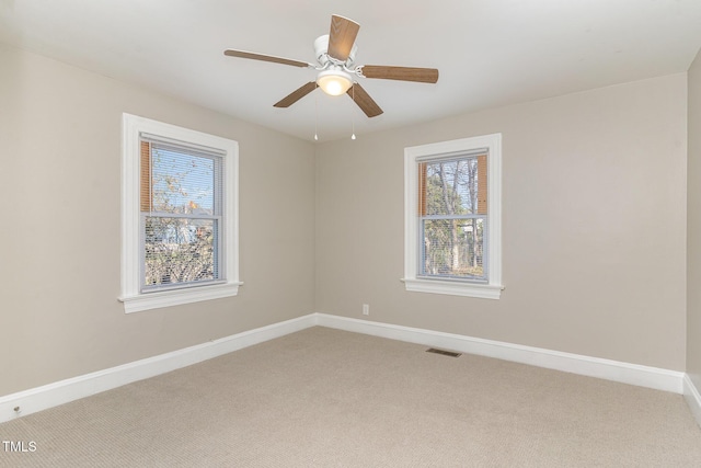 unfurnished room with light carpet, ceiling fan, visible vents, and baseboards