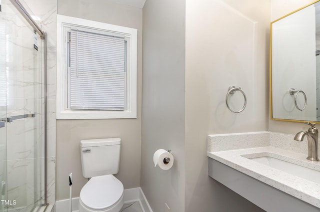 bathroom with a marble finish shower, toilet, and baseboards