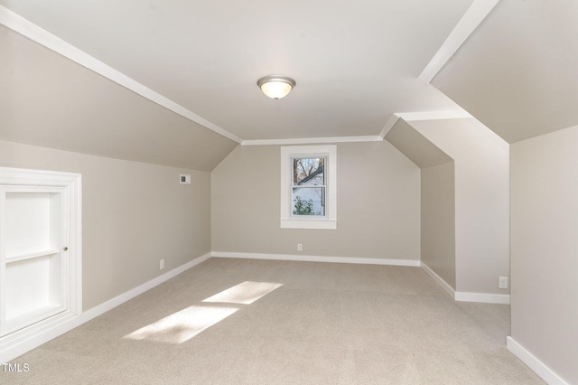 bonus room with lofted ceiling, light colored carpet, visible vents, baseboards, and built in features