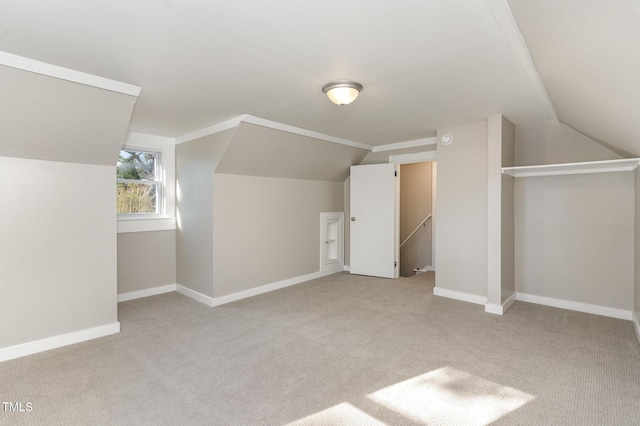 additional living space featuring lofted ceiling, light carpet, and baseboards