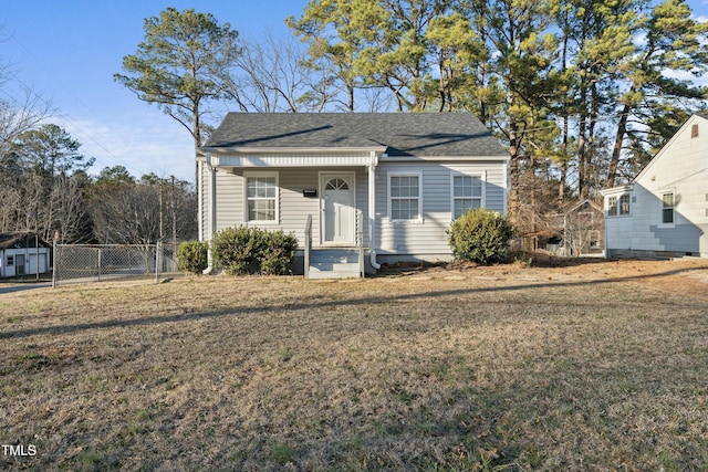 bungalow featuring fence, a front lawn, and roof with shingles