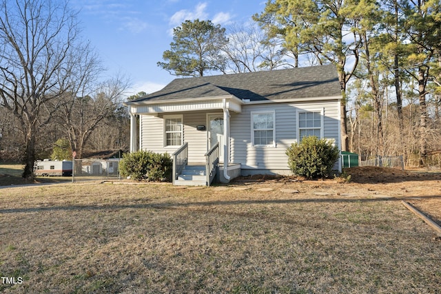 bungalow with roof with shingles, a porch, and a front yard