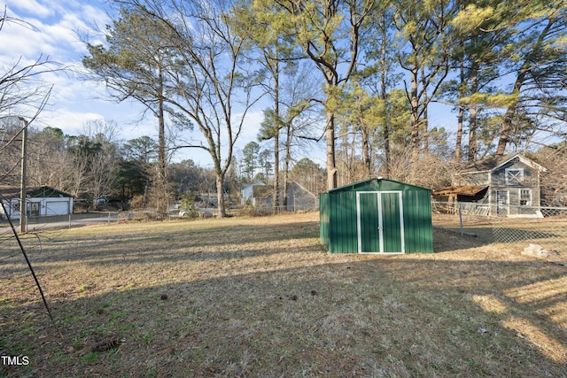 view of yard featuring a shed, an outdoor structure, fence, and a detached garage