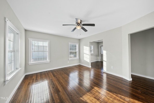 empty room featuring a ceiling fan, baseboards, visible vents, and hardwood / wood-style floors