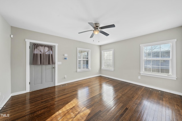 interior space with wood-type flooring, visible vents, and baseboards