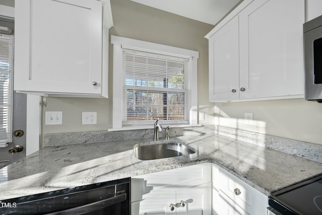 kitchen with stainless steel microwave, a sink, dishwasher, and white cabinetry