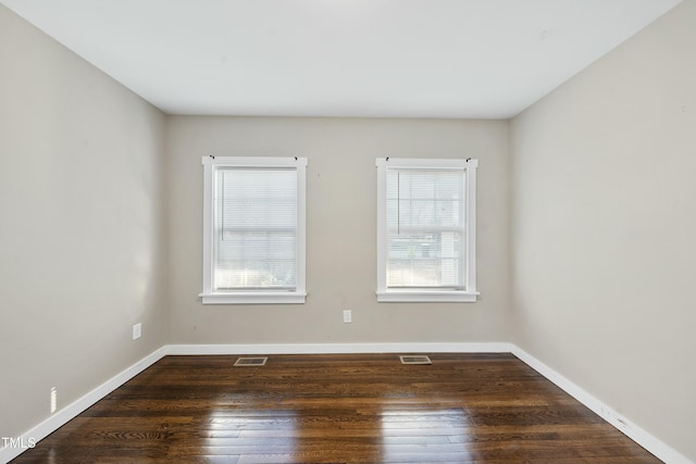 unfurnished room featuring a wealth of natural light, hardwood / wood-style flooring, and visible vents