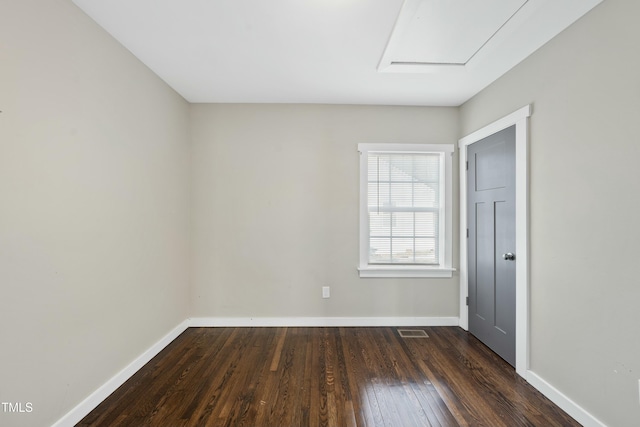 spare room featuring hardwood / wood-style flooring, baseboards, and visible vents