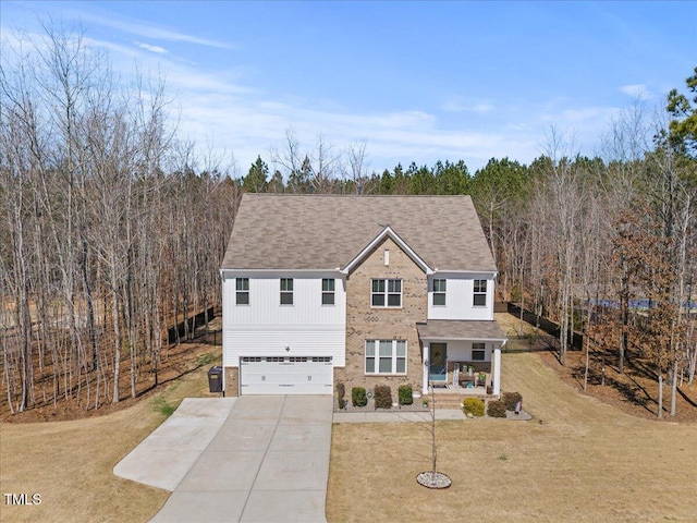 view of front of property with a front lawn, concrete driveway, covered porch, and a garage