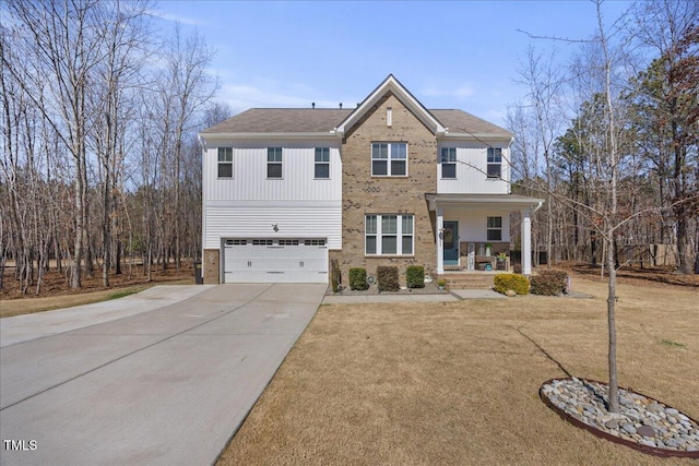 view of front of house featuring brick siding, a front lawn, covered porch, a garage, and driveway