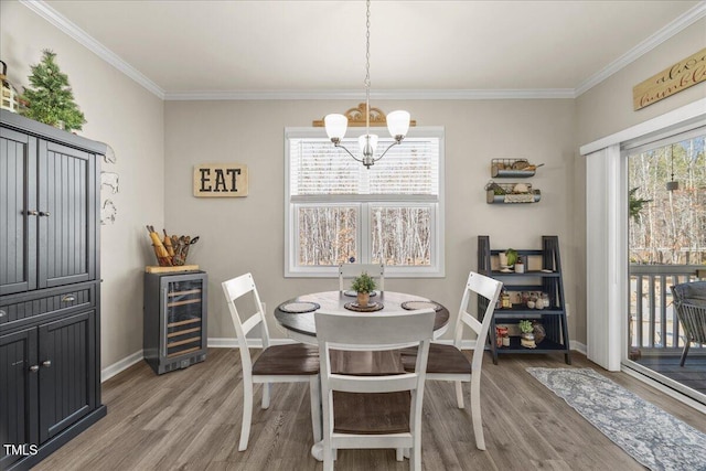 dining area with crown molding, wine cooler, a notable chandelier, and light wood-type flooring