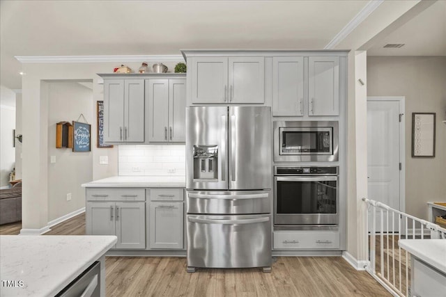 kitchen with visible vents, light wood finished floors, and stainless steel appliances