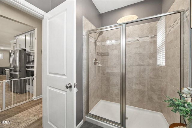 bathroom with a shower stall and wood finished floors