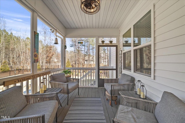 sunroom featuring wood ceiling and a healthy amount of sunlight