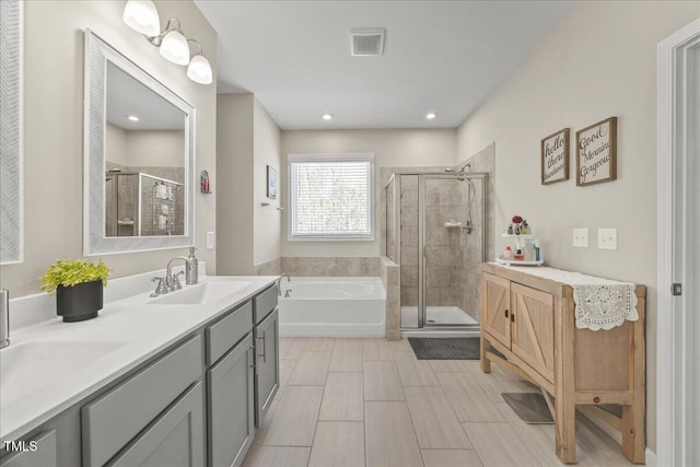 bathroom featuring visible vents, a stall shower, a sink, double vanity, and a bath