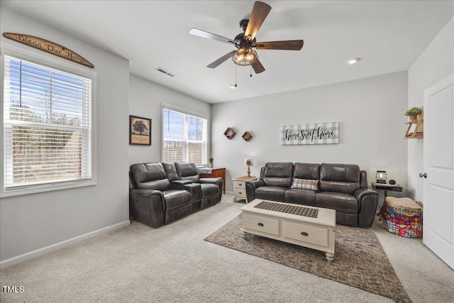 living area with visible vents, baseboards, carpet, and ceiling fan